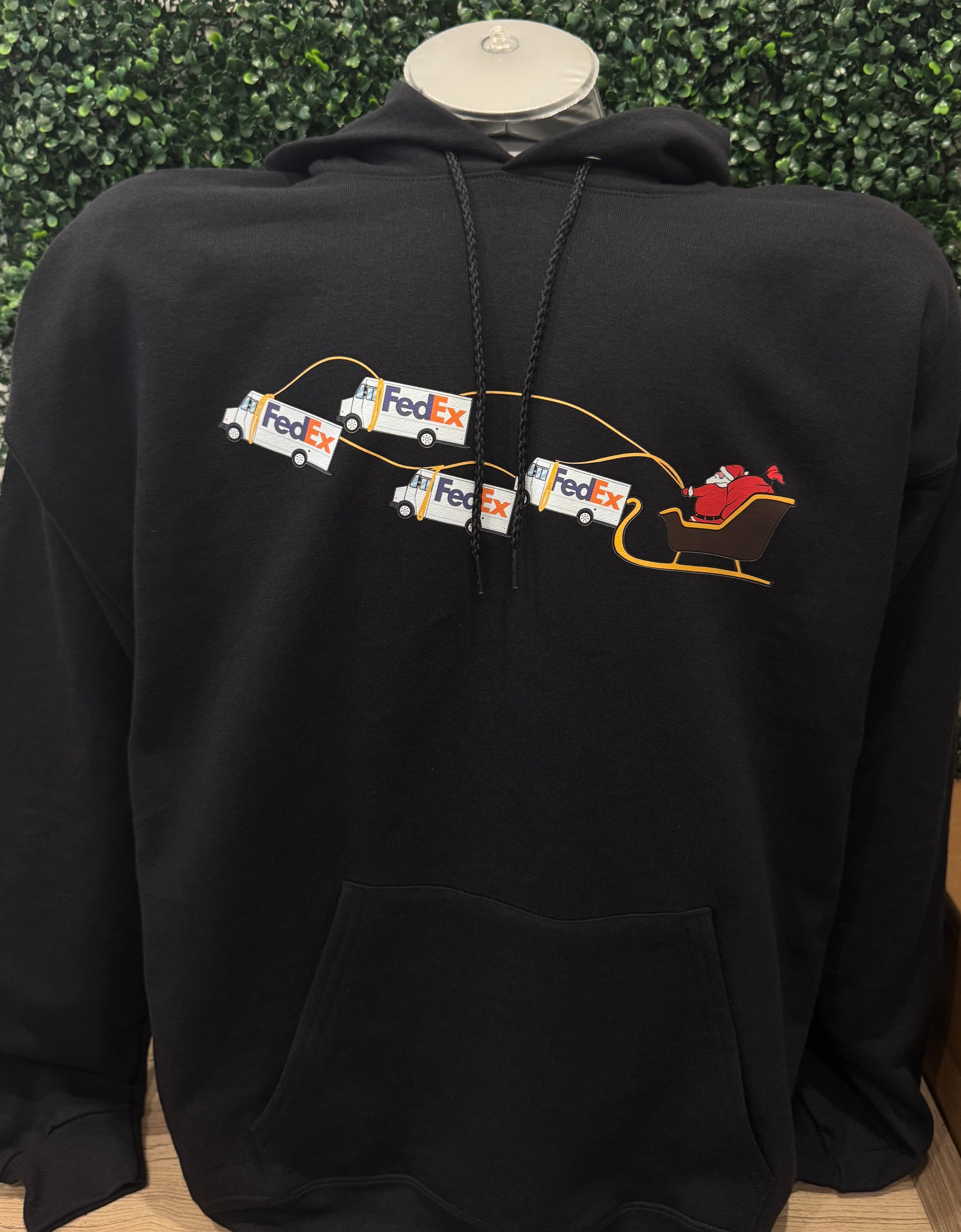 Black hoodie with FedEx logo on the back against a green leafy background